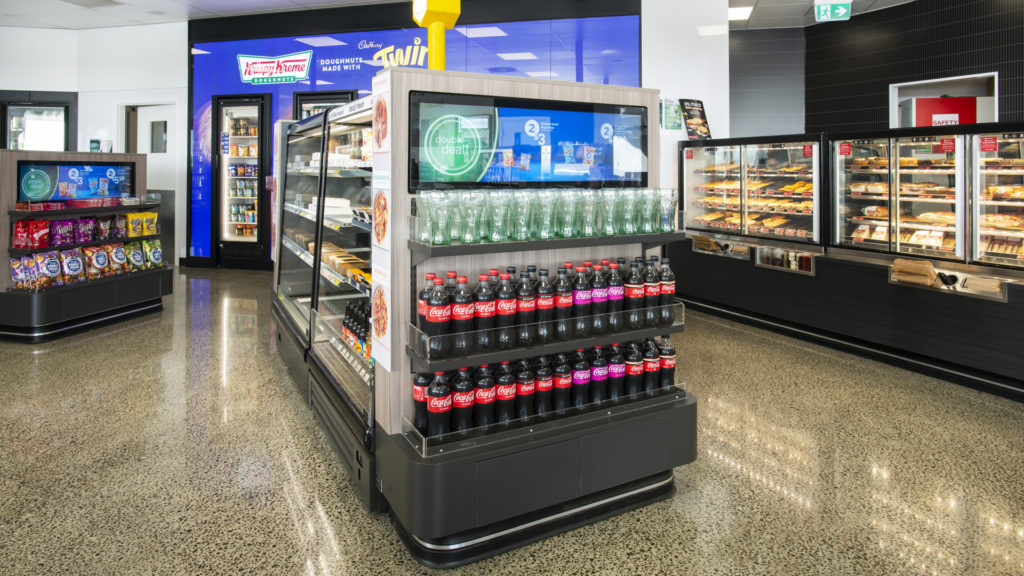 Image showing lineup of FPG Inline 5000 in-counter cabinets and an island of FPG Visair Upright cabinets with ambient gondola display ends at BP Tauranga, New Zealand.