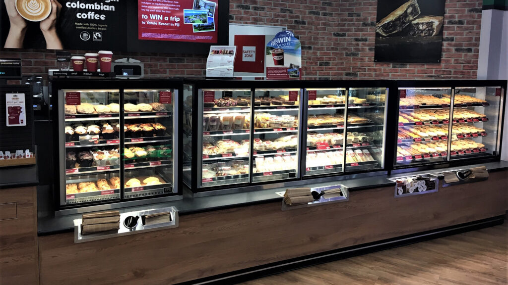 An image showing a lineup of FPG Inline 5000 Square refrigerated and heated food display cabinets at BP Albany, New Zealand.